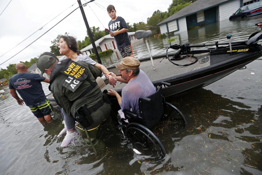 Members of the Louisiana Department of Wildlife and Fisheries help rescue Mike Henry, right, and his partner Rosemarie Carpenter during flooding from Tropical Storm Harvey in Orange, Texas, Wednesday, Aug. 30, 2017. 