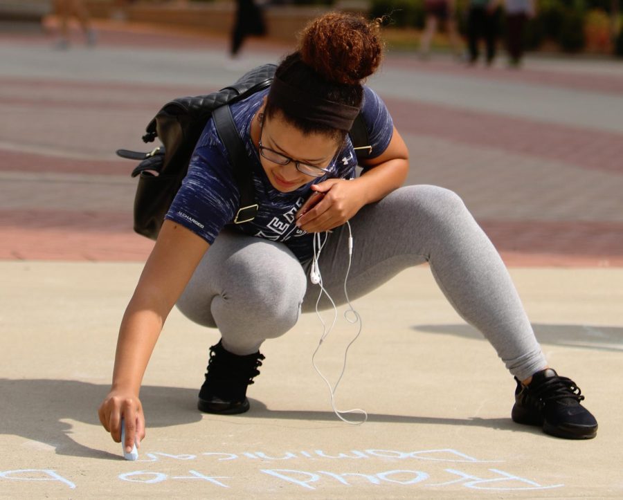 Melissa Perez, junior nursing major, writes “Proud to be Dominican” in chalk on Risman Plaza during SALSA's “Proud to be_____” chalking event on Monday, Sept. 18, 2017.