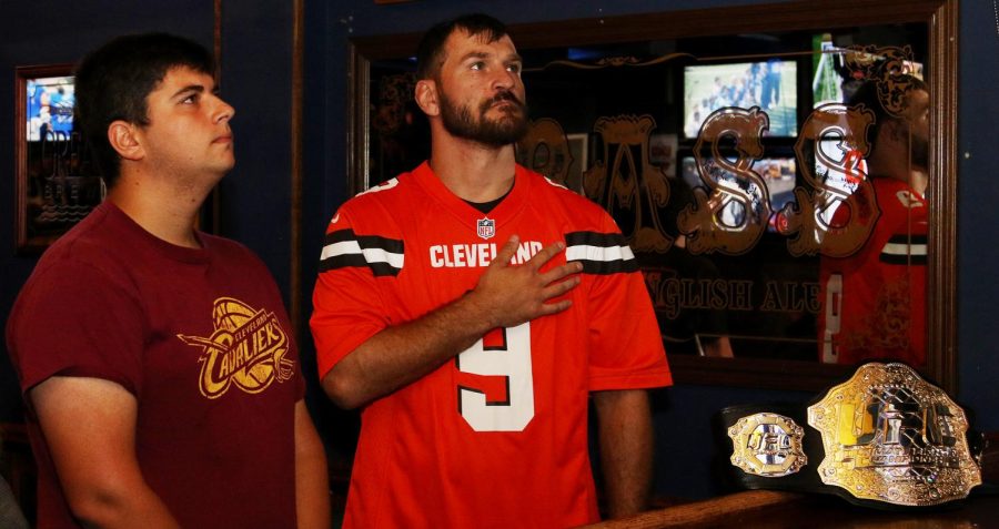 UFC heavyweight champion Stipe Miocic stands with a fan in Water Street Tavern while the national anthem played before the Cleveland Browns game on Sunday, Sept. 24, 2017.