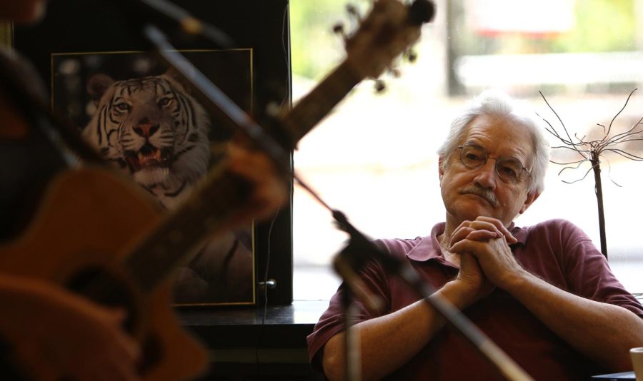 Rich Patterson of Kent, Ohio, listens as Gretchen Pluess of Akron plays inside BAKED in the Village Cafe Friday. Pluess was one of dozens of artists performing in downtown Kent for the Round Town Music Festival.