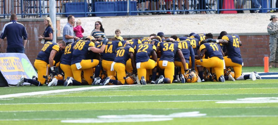 A+group+of+Kent+players+kneel+and+pray+before+the+home+opener+against+Howard+on+Saturday%2C+Sept.+9%2C+2017.
