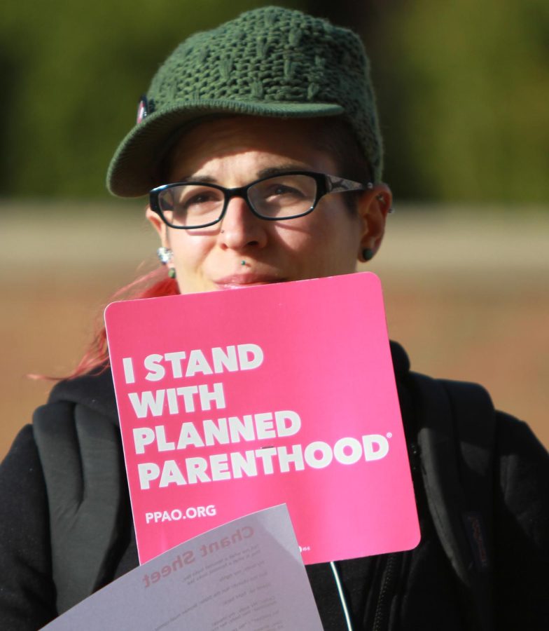 Alyx Weaver, a neurology graduate student, holds a sign during a Planned Parenthood rally on Risman Plaza.