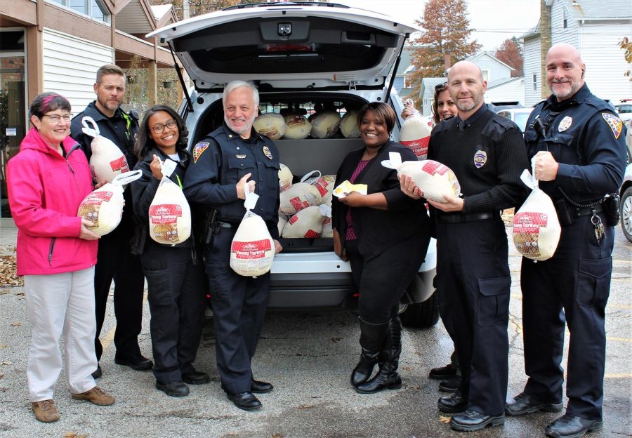 Members of Kent State Police Department and Marquice Seward, the assistant programming manager for Kent Social Services (center), pose with turkeys ready to be donated to Kent Social Services purchased from Acme.