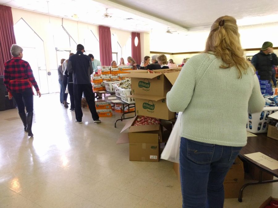 Volunteers pack food at the United Methodist Church of Kent Wednesday, Dec. 6, 2017, which they will give to food-insecure families in the area.