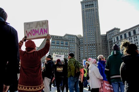 A woman stands among the crowd with an “I AM WOMAN” sign during the Women’s March in Clevelands Public Square.