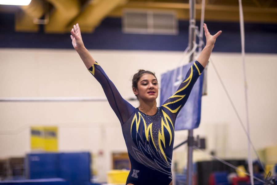 Senior Michaela Romito finishes a bar routine in the gymnastics practice room in the M.A.C. Center Friday. Romito suffers from Crohn’s disease, an autoimmune disease attacking the digestive tract, and chooses to do gymnastics for Kent State despite her disease. 