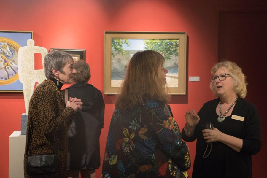 Artist Carol Tomasik (right) talks about her work to guests at the reception for the annual Members and Friends show Friday, Feb. 24, 2018.