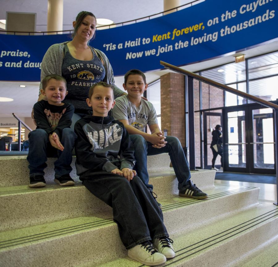 Angela Jarrells and her children, from left to right, Eli, Evan and Ethan sit on the steps in the Student Center. Angela takes classes at Kent while looking after her three children.