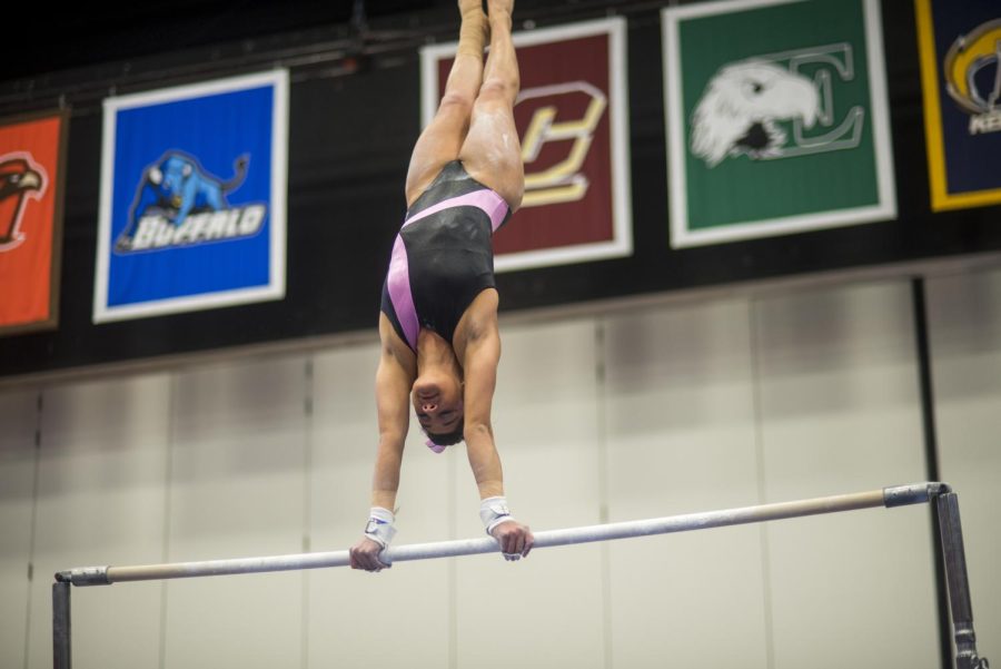 Senior Michaela Romito suspends upside-down on the uneven bars during Kent State’s annual Pink meet. 