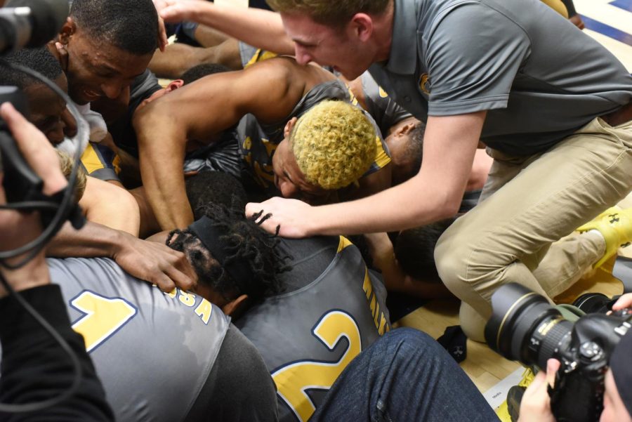 Kevin Zabos teammates pile on top of him after he scored the game-winning basket on March 5, 2018. The Flashes won, 61-59, in the first round of the Mid-American Conference tournament.