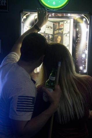 (1:40am) Jarett and Katie search through a juke box at the Ace of Diamonds in Diamond, Ohio, Saturday morning, April 21, 2018. Alex Cossin / The Kent Stater