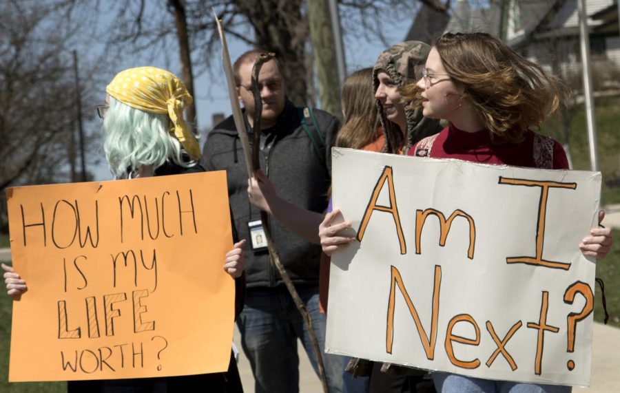 (12:09pm) Kreigh Barnette (right), junior Roosevelt High School student, holds a sign and looks towards traffic along Main Street in front of the Portage County Municipal Court in Kent, Ohio during a student organized walk out for common sense gun reform Friday, April 20, 2018. “ I don’t want it to lose steam,” Barnette said. “It’s important to show up and have students lead the group.” Carter Adams / The Kent Stater