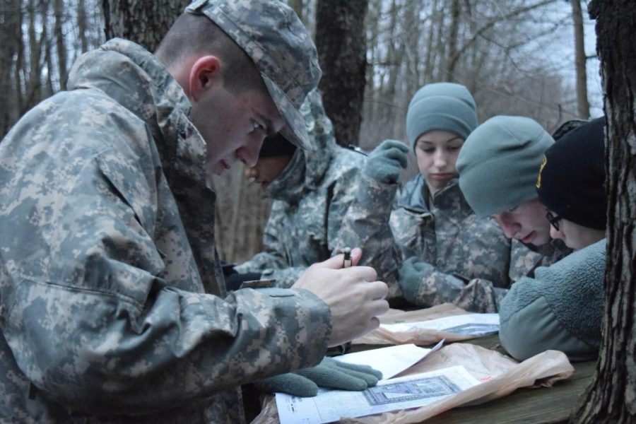 Cadets gather in the woods to map out their coordinates for the land navigation lab. Visible: Blake Bishop, a political science major and freshman cadet.