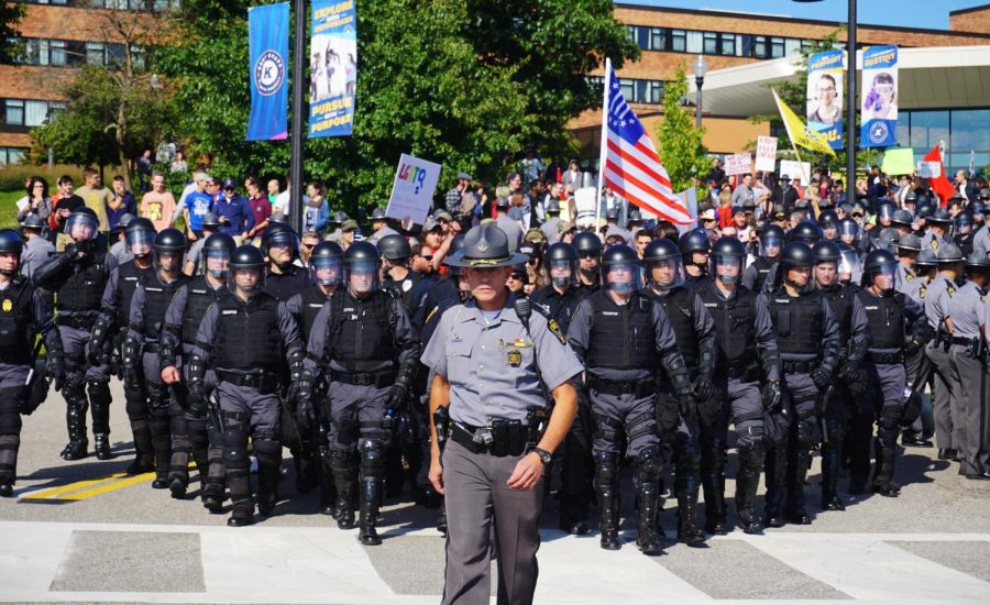 An Ohio police officer leads police in riot gear toward the Schwartz Center parking lot on Saturday, Sept. 29, 2018 after an open-carry walk stalled in front of Bowman Hall.  