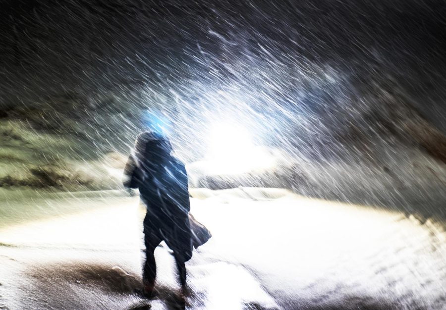 A person walks through a snowstorm in Kent, OH, March 14, 2017. Joseph Ortiz, a professor in the department of geology at Kent State University, said that as the planets temperature increases, it could cause lake effect snow produced by the Great Lakes to turn into lake effect rain.