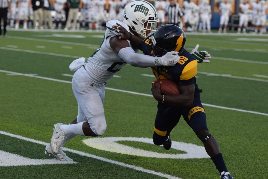 Kent States Antwan Dixon attempts a stiff-arm during the second half of the Flashes matchup against Ohio University on Oct. 6, 2018. Kent lost the game, 27-26.