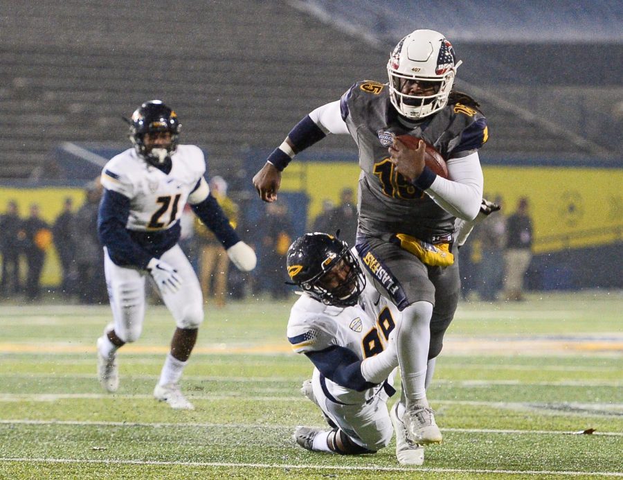Kent State Golden Flashes quarterback Woody Barrett carries the ball out of the tackle of Toledo Rockets defensive lineman Tuzar Skipper in the first quarter of Thursday's game at Dix Stadium. Barrett scored on the play.