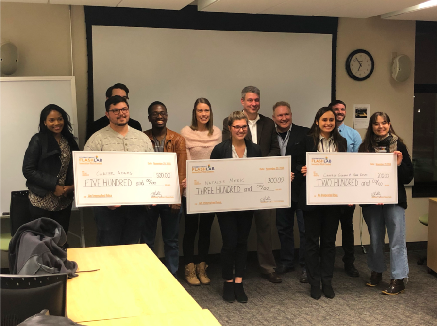 Carter Adams, Natalie Meek, Anna Katsas and Cameron Gorman (left to right, holding checks) stand with the other finalists and judges following the FlashLab Innovation Pitch Final.