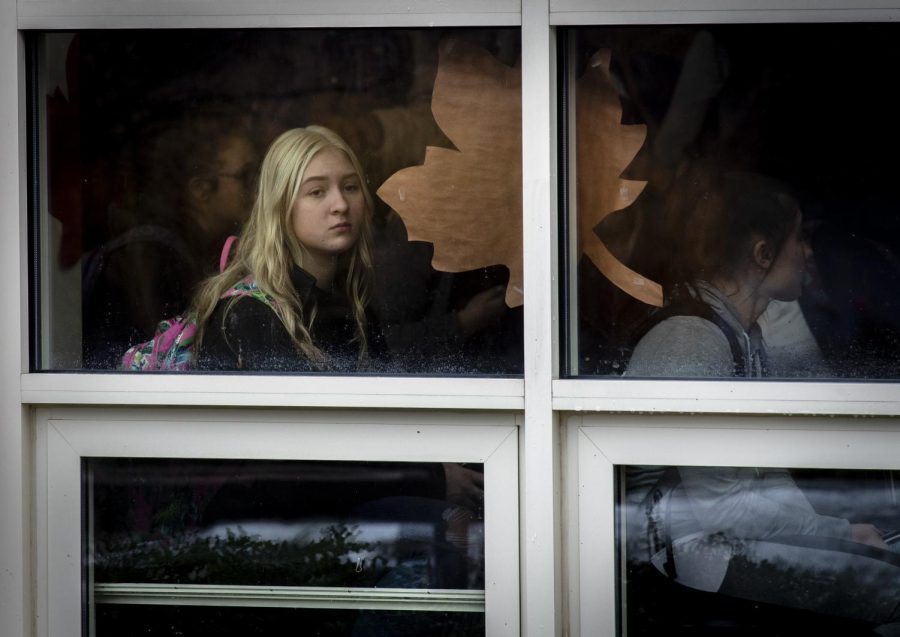 A Ravenna High School student looks out a window while waiting to be released after a lockdown Friday morning. Two students are in custody, and there were no injuries.