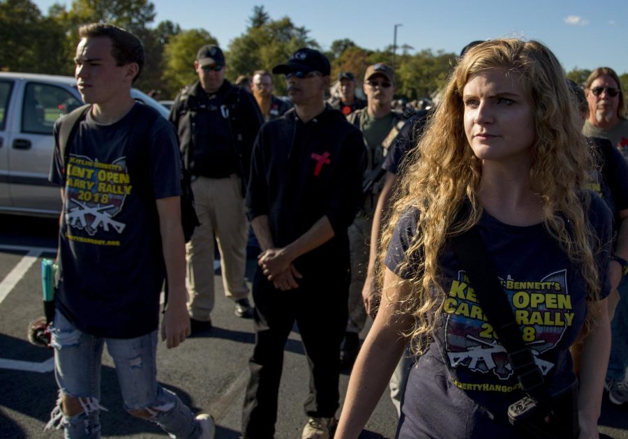 Kaitlin Bennett, the organizer of an open-carry walk on Kent States main campus, walks back to her car with her personal security detail at the end of the walk on Sept. 29, 2018.