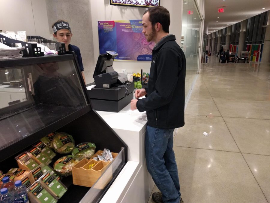 Sophomore architecture major Caleb OBryon uses his meal plan to purchase food at the George T. Simon III Cafe on Wednesday, November 14.
