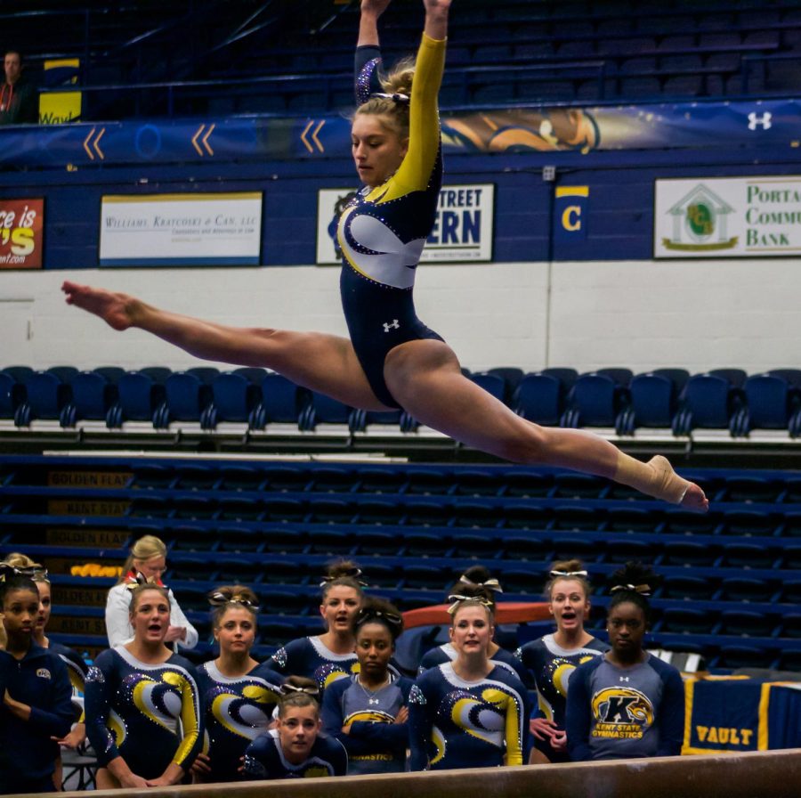 Kent State's Sarah Lippowitsch goes through her beam routine as her team looks on during the Flashes' 195.625-195.400 win over Bowling Green on March 9, 2018, at the M.A.C. Center.