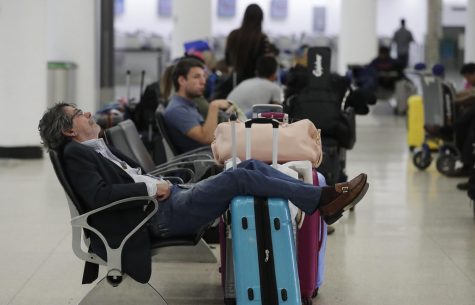 A traveler sleeps near a closed down terminal at the Miami International Airport on Saturday, Jan. 12, 2019, in Miami. The partial government shutdown is starting to strain the national aviation system, with unpaid security screeners staying home, air-traffic controllers suing the government and safety inspectors off the job.(AP Photo/Brynn Anderson)