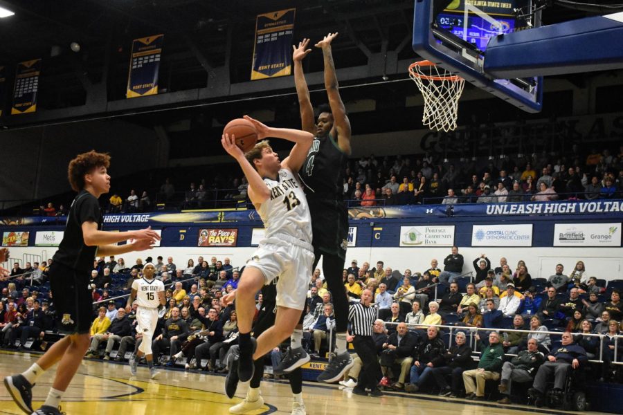 Mitch Peterson attempts to shoot over Ohio’s Teyvion Kirk in the first half of Kent State’s game on Tuesday. The Flashes won, 78-73.
