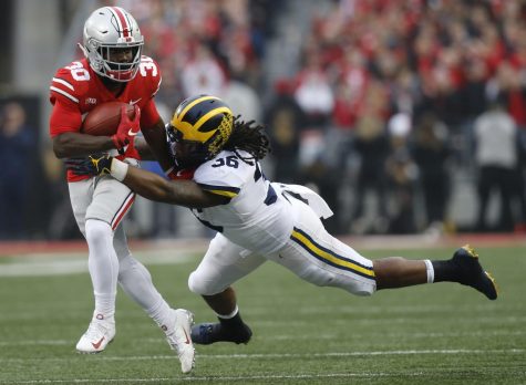 Michigan linebacker Devin Gil, right, tackles Ohio State running back Demario McCall during the first half of an NCAA college football game Saturday, Nov. 24, 2018, in Columbus, Ohio. (AP Photo/Jay LaPrete)