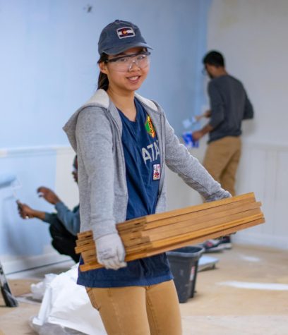 Sarah Audet, a freshman Architecture major, smiles for a picture while carrying boards from room to room.