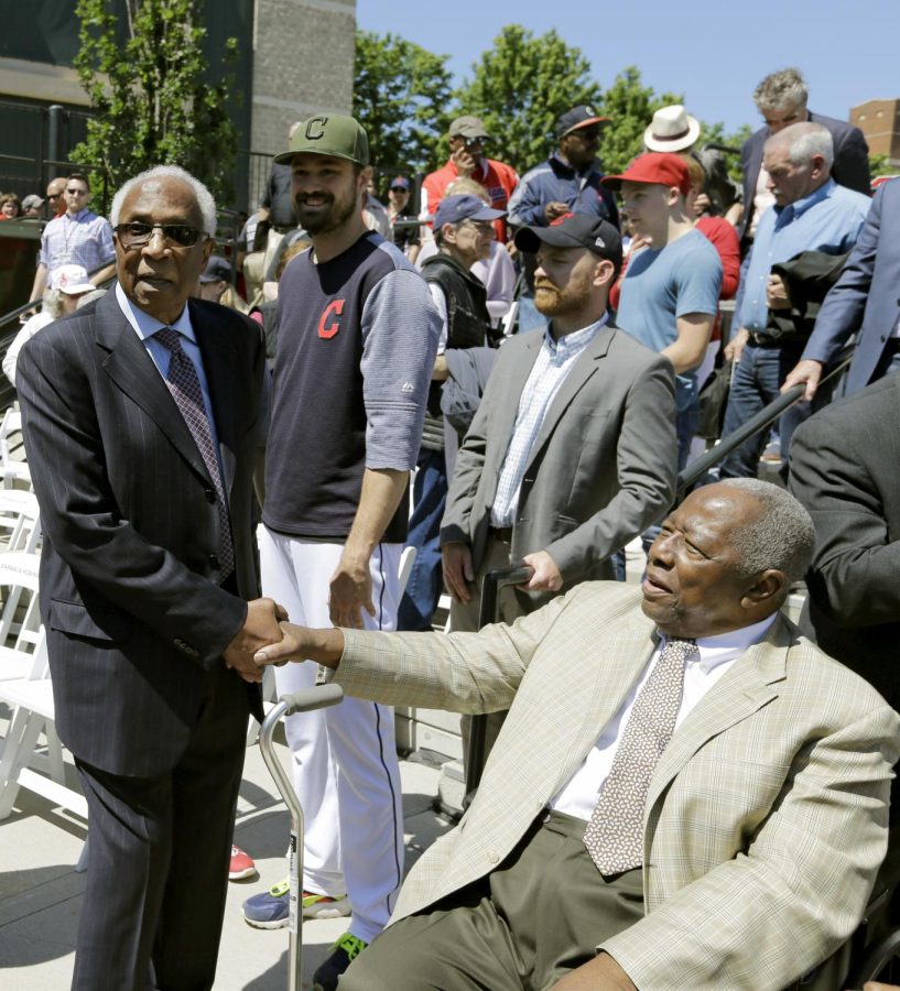 Frank Robinson, left, greets Hank Aaron before a game between the Kansas City Royals and the Cleveland Indians, May 27, 2017, in Cleveland. Robinson was MLB’s first African-American manager.