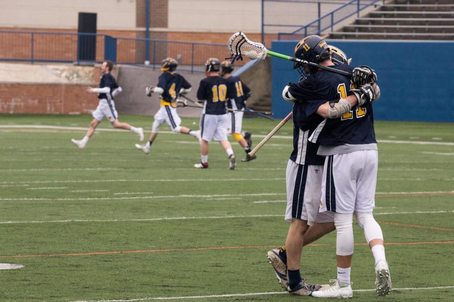Brian Dureiko (11) and Andrew Rackley hug after the Kent State Lacrosse Club beat Penn State Altoona 9-5 on Saturday, April 29, 2017. The Flashes won the Midwest conference with the victory. 