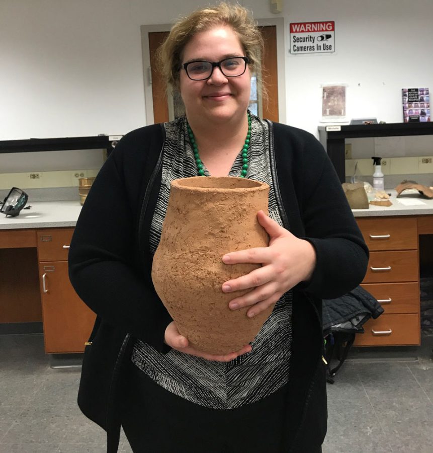 Ashley Rutkoski, an anthropology graduate student, poses Wednesday, March 13, 2019, with the first pot she made for her thesis experiment. Rutkoski made more than 30 pots for her experiment, but only broke the ones that were the most identical so it would not skew the data.