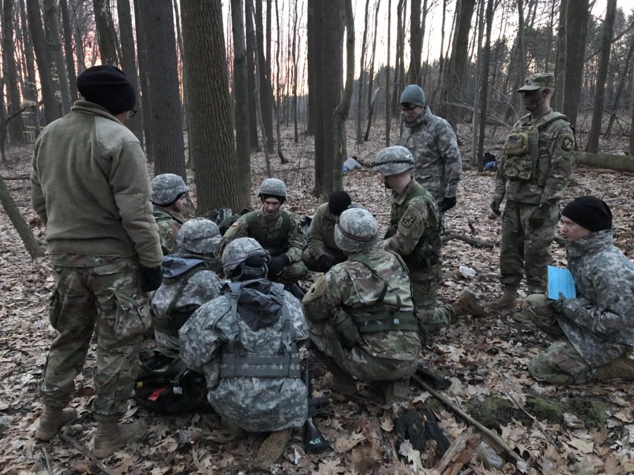 Cadets discuss their mission in the woods by Allerton Sports Complex as they train for Advanced Camp. 