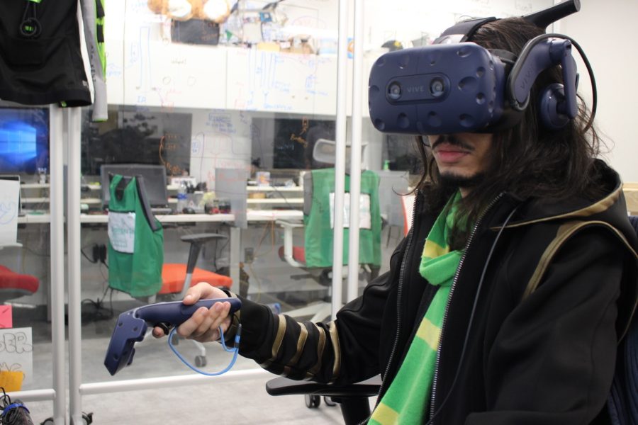 Alfred Shaker, computer science graduate student, demonstrates the virtual reality headset and hand device that participants used in the experiment April 2, 2019.