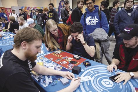 Natalie Shampay stands next to her friend, Riley Hulbert (seated), after he won a match to earn a spot in the top 8 round of the 2019 St. Louis Pokémon Regional Championship in Collinsville, Ill. on Feb. 23, 2019.