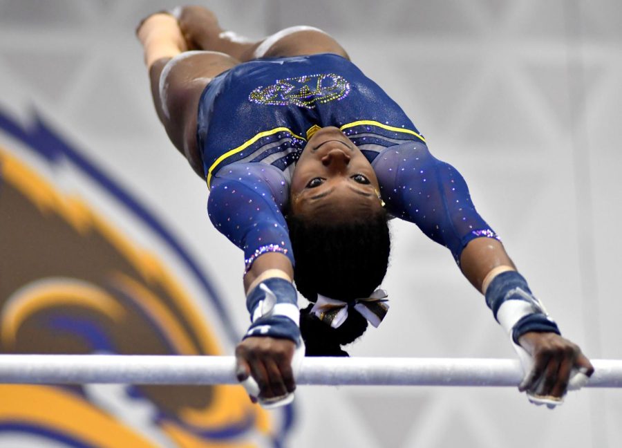 Sophomore Dara Williams performs on the uneven parallel bars during Kent State Universities Beauty and the Beast double meet event for gymnastics and wrestling Saturday Feb. 4, 2017.