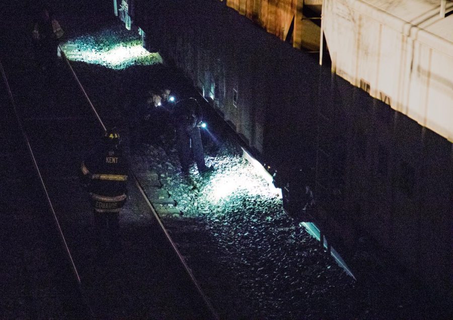 First responders look for the remains of a person who died near the railroad tracks next to the Cuyahoga River in downtown Kent on Wednesday, April 17, 2019.