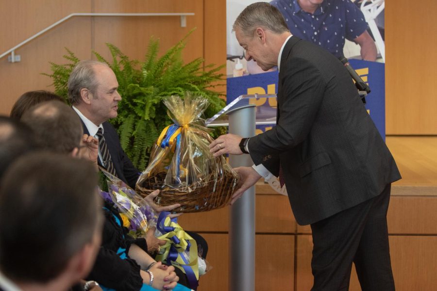 Shawn Riley, board member and leader of the presidential search committee, gives President-elect Todd Diacon a bouquet of flowers and a gift basket. 