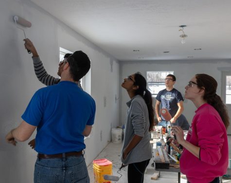 Habitat for Humanity of Portage County construction manager Brittian Bollenbacher teaches Kent State volunteers how to evenly roll paint onto the living room walls. Feb. 2, 2019.