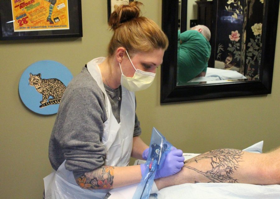Kent State alumna and South Water Studios tattoo artist Wendi Koontz tattoos Cuyahoga Falls local Bruce Neal on Tuesday, April 18, 2016. FILE.