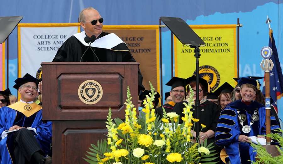 Michael Keaton, the commencement speaker at Kent State’s 2018 graduation ceremonies, said he “wanted to come clean about something” and admitted, “I never really liked school.” Kent State President Beverly Warren reacts at right.