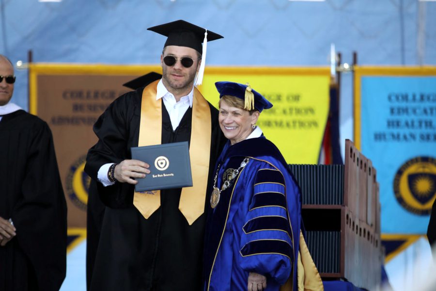 Julian Edelman, wide receiver for the New England Patriots, poses with President Beverly Warren after accepting his degree in integrative studies on May 11, 2019.