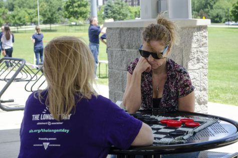 Debbie Dobrilovic (right) deliberates her next checker move against Kathi Meeker (left), both staff members of Information Technology, during The Longest Day event. The event was held in the student recreational fields near Stewart Hall where Dobrilovic and Meeker work so they came out to enjoy the nice weather.