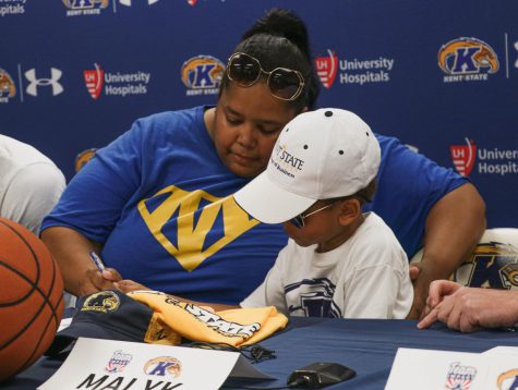 Five-year-old Malyk Foster (right) signs a letter of intent to become a Kent State Golden Flash with help from his mom, Danielle Foster, in the Kent State Mac Center on Aug. 26, 2019.