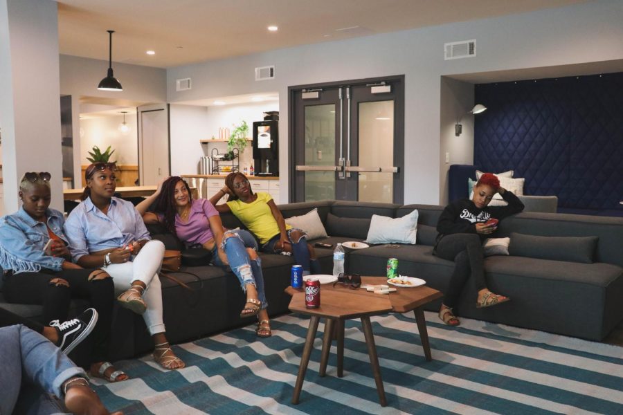 A group of a Latitude residents relax and watch TV in the lounge of the new apartment complex, Latitude on Aug. 24, 2019.