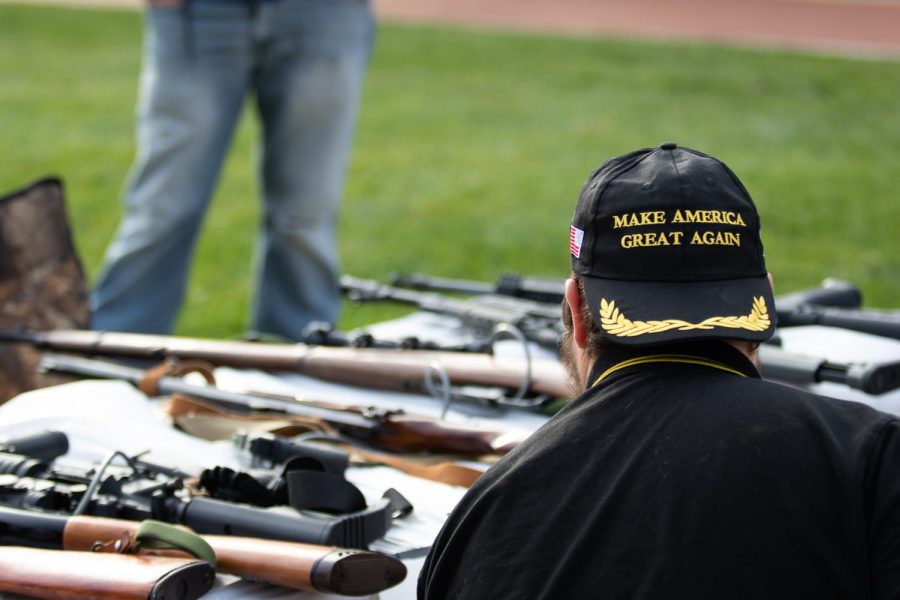 Ron Jones, a member of the Akron-Canton Proud Boys, tends to their table that displays a collection of guns.