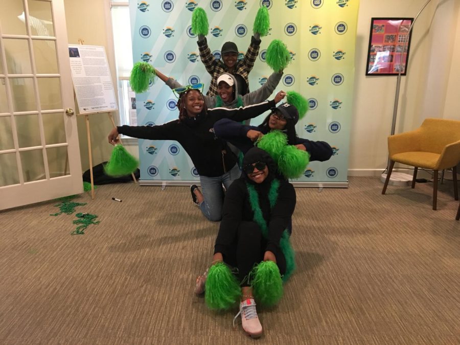 Members and executive board members of Sister Circle pose in front of the Green Dot backdrop on Sept. 28 in the Women’s Center.
