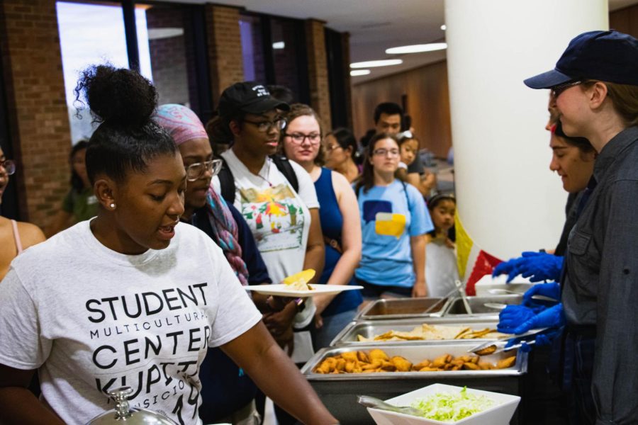 Amauri Williams (left), a senior fashion merchandising major, samples food from the Hispanic Heritage Event on the 2nd floor of the Kent State Student Center. Sept. 25, 2019
