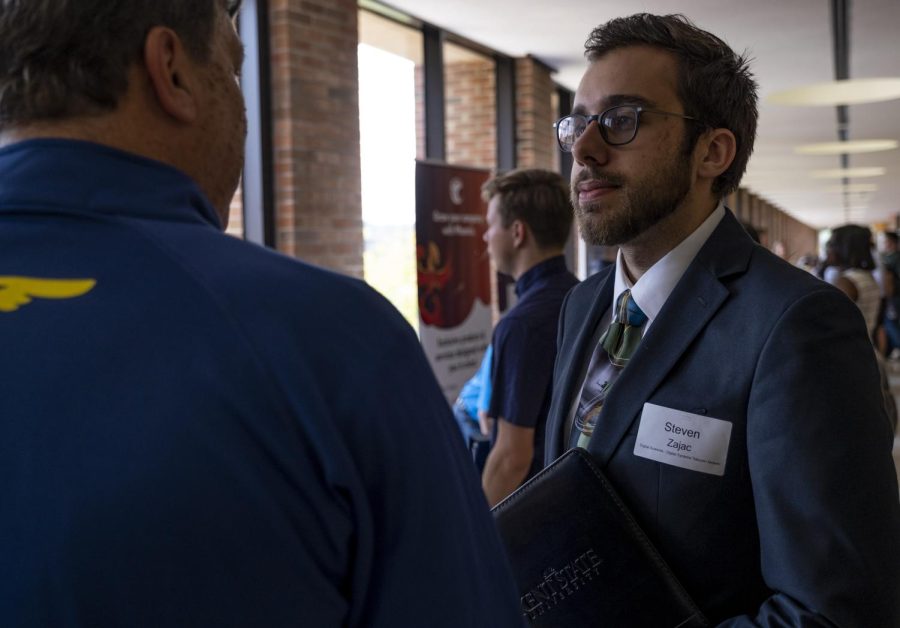 Junior digital sciences major Steven Zajac speaks with a representative from Goodyear Tire at the IS/IT Meet & Greet on Wednesday, September 11, 2019.